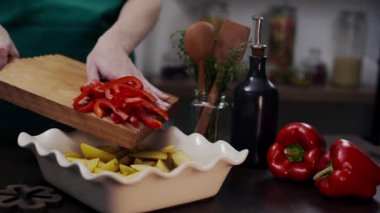 Aşçı kırmızı biber ve diğer sebzelerle yemek yapar.