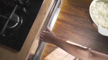 Aşçı pişirme ve ızgaraya çiğ malzemeyle tava koyar.