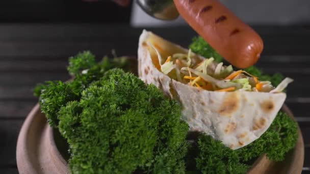 Kocken gör tortilla med färska gröna grönsaker och grillad korv — Stockvideo