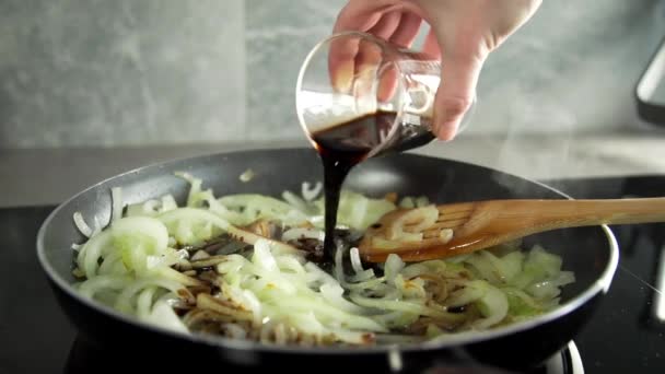 Der Koch macht Gemüsegericht mit in Balsamico-Essig gebratenen Zwiebeln und fügt Spinat hinzu — Stockvideo