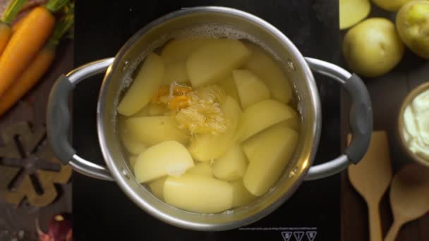 Der Koch legt blanchiertes Gemüse zu den Kartoffeln ins kochende Wasser — Stockvideo