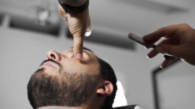 berber müşteriyi jiletle traş eder.