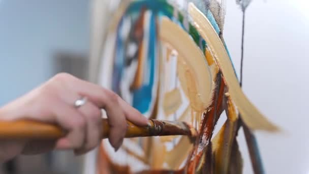 芸術家はスタジオで情熱を持って創造的な絵画を描き — ストック動画