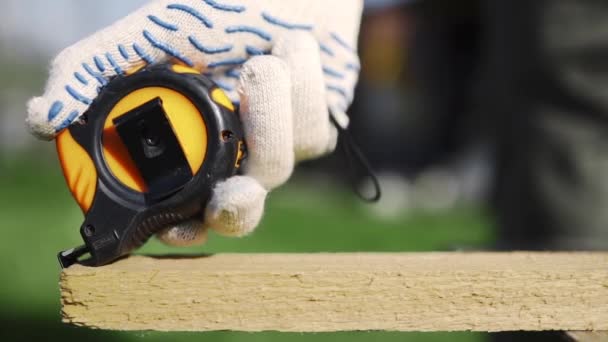 Close up of man in working gloves measuring wooden block — Stock Video