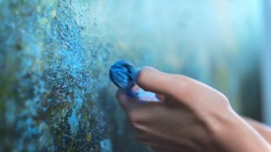 İşyerindeki ressam, sanat eseri fırçaları ve resimler yapıyor.