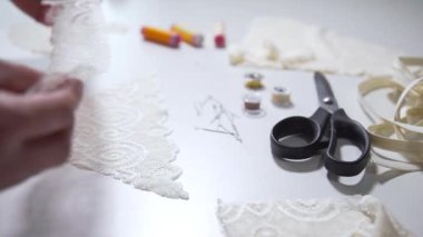 Terzi, kesim için dantel kumaş hazırlıyor.