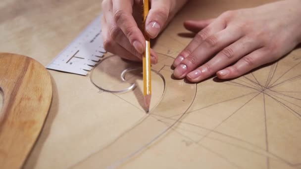 De ingenieur tekent op een papier met een potlood op maat maakt patroon voor naaijurken — Stockvideo