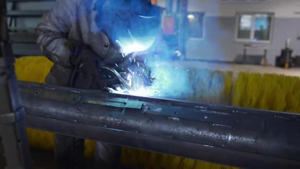 戴防护面罩和工作服的焊机在工厂车间焊接金属结构 — 图库视频影像