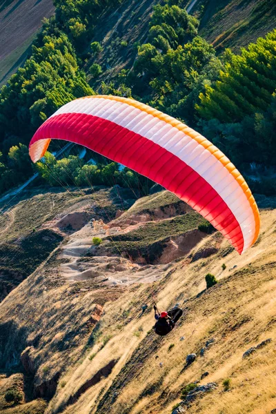 Gün batımında gökyüzü ve bulutlarla paraşütle atlayan