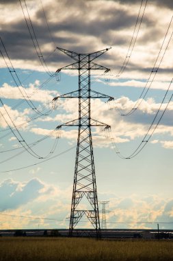 Yüksek voltajlı elektrik direkleriyle gün batımı manzarası