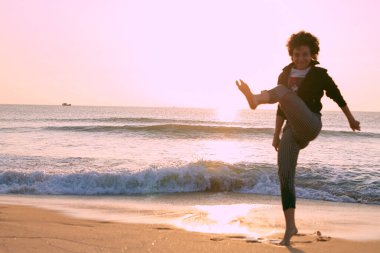 Atletik genç beyaz kız güneşli bir sabah sahilde koşuyor.. 