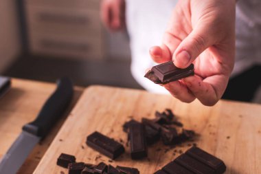 Mutfakta siyah çikolatayı tutan el.