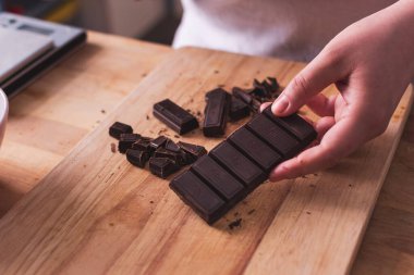 Mutfakta siyah çikolatayı tutan el.