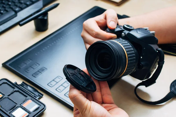 Tanımlanamayan kişi kamerayı tutuyor ve iş yerindeki lens kapağını çıkarıyor.