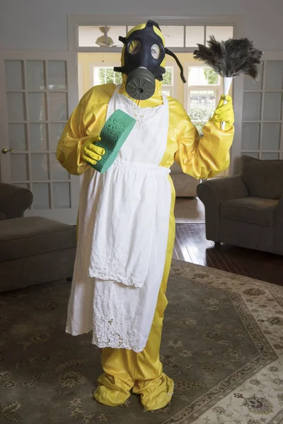 Mature woman in Haz Mat suit with feather duster and sponge