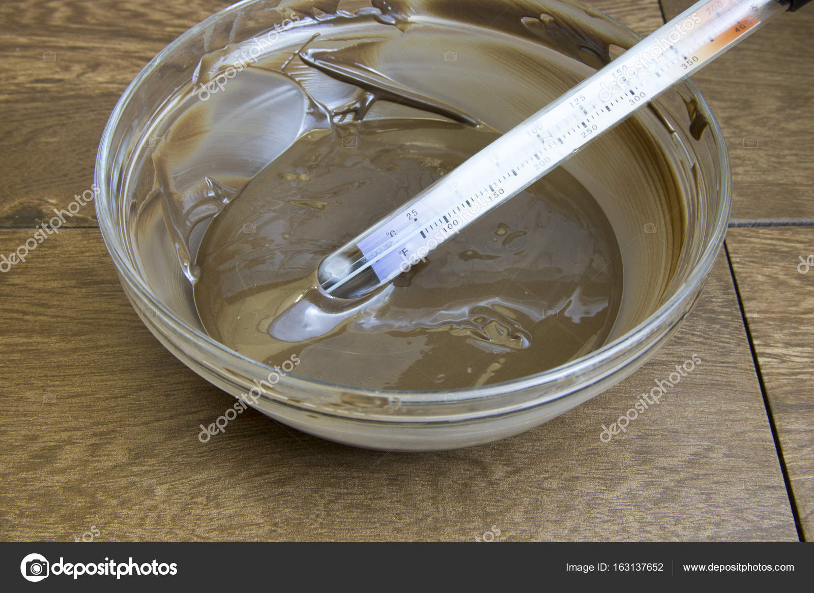 Candy thermometer in bowl of tempered chocolate Stock Photo by