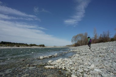 Yeni Zelanda 'da güzel mavi dere kenarında yürüyen bir adam..