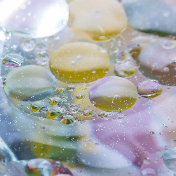 Sudaki yağ damlaları uzaya benzer muhteşem görüntüler oluşturur. Makro. Soyutlama.