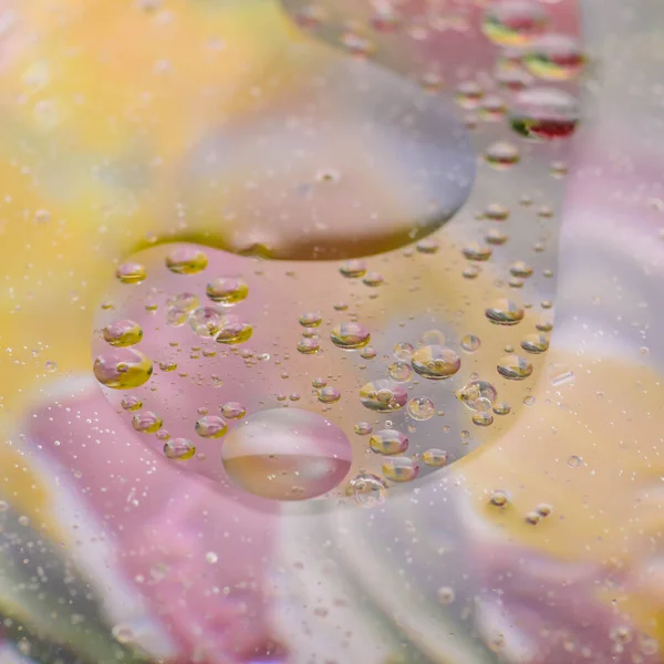 Drops of oil in the water create fantastic pictures similar to space. Macro. Abstraction.