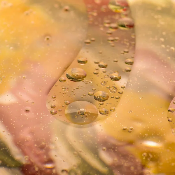 Sudaki yağ damlaları uzaya benzer muhteşem görüntüler oluşturur. Makro. Soyutlama.