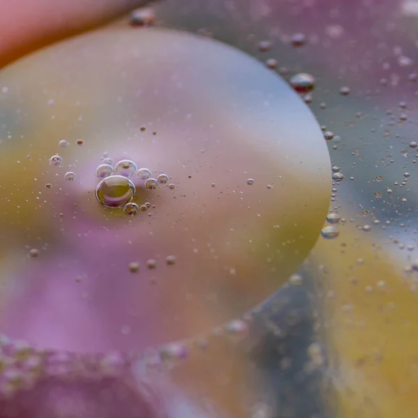 Sudaki yağ damlaları uzaya benzer muhteşem görüntüler oluşturur. Makro. Soyutlama.
