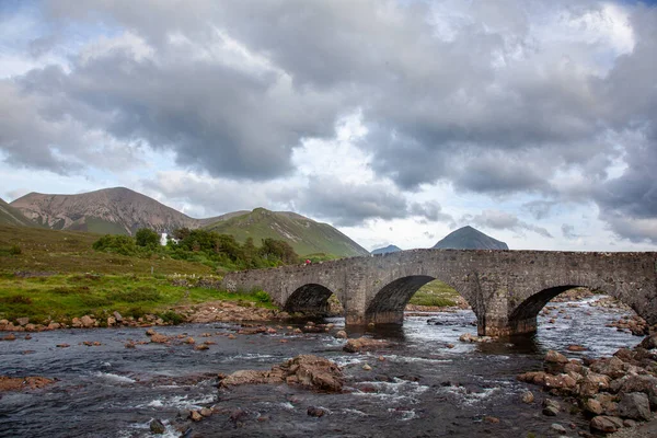 İskoçya, İskoçya, İskoçya 'daki Sligachan' da eski bir taş köprü. Kasvetli ve bulutlu bir öğleden sonra İskoçya yazı boyunca gökyüzünde bir sürü bulutla çekim yaptık..