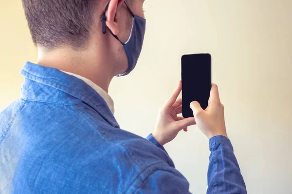 İş adamı, yüz maskesi takılı fotoğraf çekmek için telefon / mobil kullanıyor..