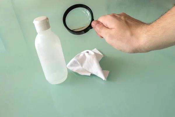 Dezenfektan, mendil ve cam zeminli büyüteç tutan bir el. Tıbbi çalışmalar, virüs ve hastalıkların araştırılması tedavi veya önleme.