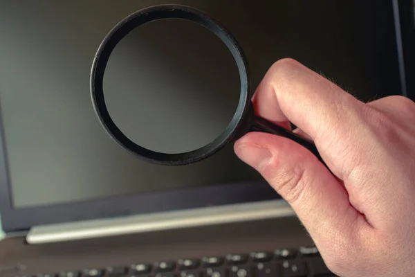 Laptopun önündeki büyüteçin basit bir fotoğrafı. Arama, teknoloji, araştırma ve diğer şeyler için mükemmel..