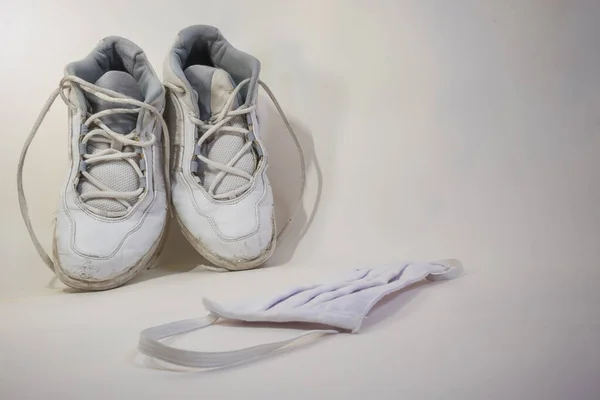 Eski beyaz koşu ayakkabıları ve beyaz bir yüz maskesi. Sosyal uzaklık için mükemmel, yeni normallik üzerine spor vs.