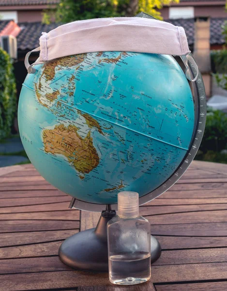 Maskeli ve dezenfektanlı dünya küresel salgını temsil ediyor.