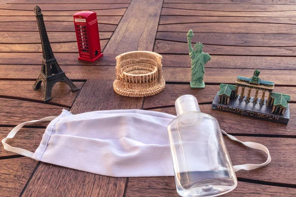 Eyfel Kulesi, ahşap bir masada kolezyum, yüz maskesi ve dezenfektan gibi ünlü anıtlar. Globlal pandemik tema ve virüsle ilgili .