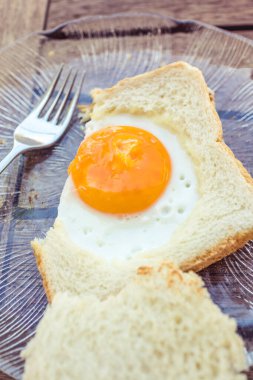 Tabak ve çatalla yumurtalı sandviçi yakın.