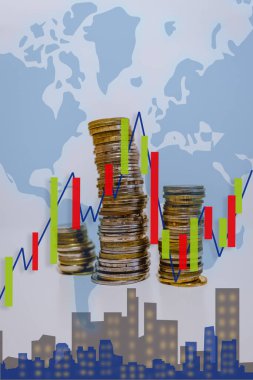 Dünya ekonomisini temsil eden madeni para kuleleri ve borsa grafiği olan bir haritanın fotoğrafı