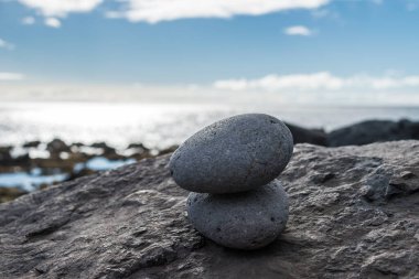 Kayalık bir sahilde üst üste iki taş.