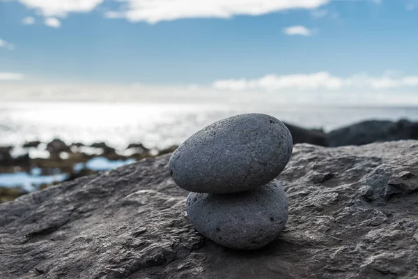 Kayalık bir sahilde üst üste iki taş.