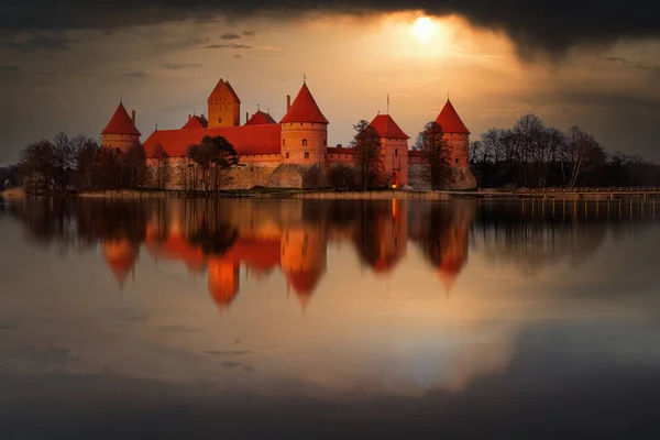 Trakai island Castle in lake Galve, Lithuania on sunset with dramatic sky reflecting in water. Trakai Castle one of major tourist attractions of Lithuania