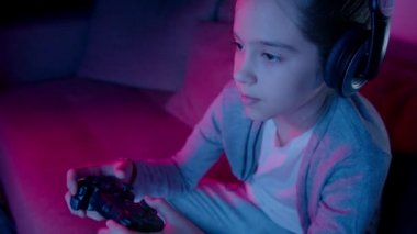 Güzel bir kız neon ışıkta bilgisayar oyunları oynar. Esporlar yavaş çekimde kapanır