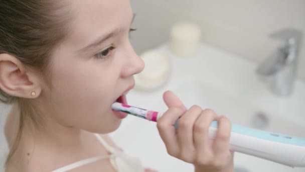 Beautiful caucasian girl brushes her teeth in the bathroom to prevent health — Stock Video