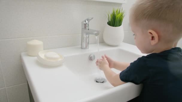 Niño pequeño lávese las manos con jabón sobre el fregadero con agua corriente COVID-19 — Vídeo de stock