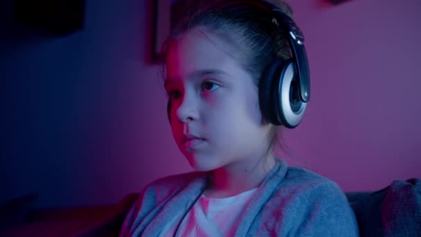 Güzel bir kız neon ışıkta bilgisayar oyunları oynuyor. Akıllı telefondan Esports — Stok video