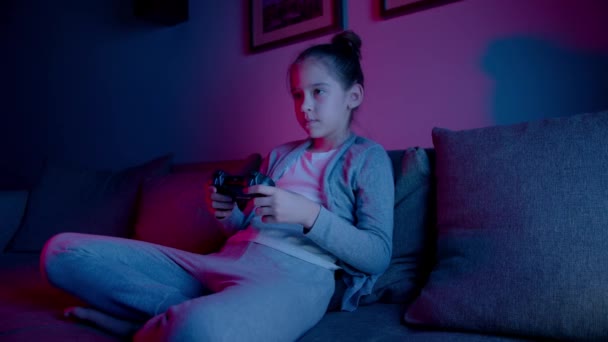 한 아름다운 소녀가 네온사인으로 컴퓨터 게임을 합니다. 스마트폰으로 즐기는 스포츠 — 비디오