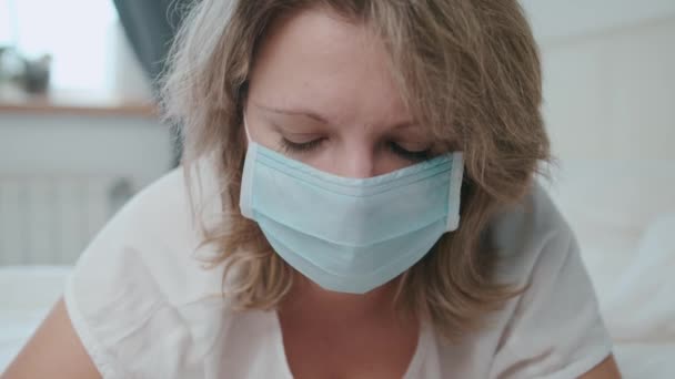 La donna con la maschera è triste e tristemente guarda la fotocamera occhi malati, virus — Video Stock