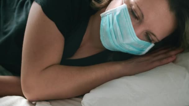 La mujer de la máscara descansa sobre la almohada. Enfermo mirada triste, ella está enferma, virus — Vídeos de Stock