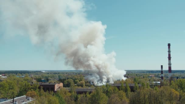 Um grande incêndio queima uma fábrica ou armazém um fogo poderoso e muita fumaça — Vídeo de Stock