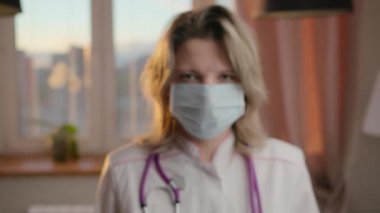 Coronavirus salgınının sonunu gösteren maskeyi çıkaran bir kadın doktorun yakın çekimi.