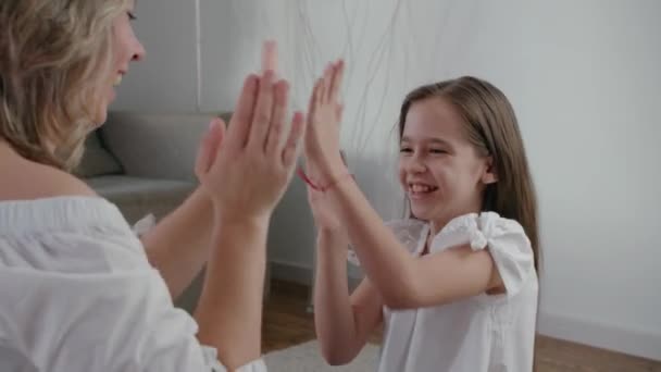Joyeux caucasien famille maman et mignon petit enfant fille applaudir leurs mains et étreindre drôle visage et sourire lent mouvement fermer — Video