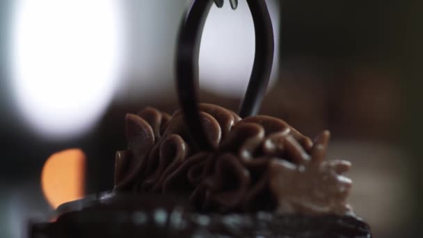 The chef completes the decoration and inserts a piece of dark chocolate with tweezers into the cut slice of the cake — Stock Video