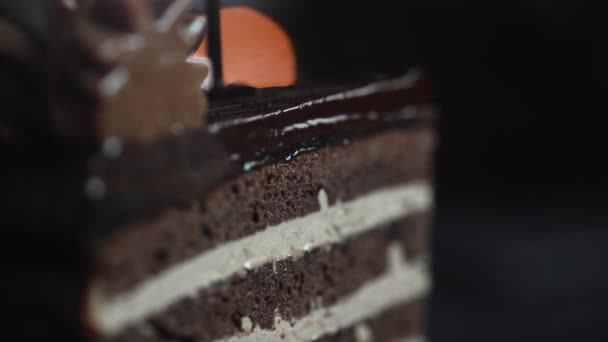 Kocken avslutar dekorationen av desserten och häller den skivade tårtbiten med varm mörk choklad på nära håll — Stockvideo