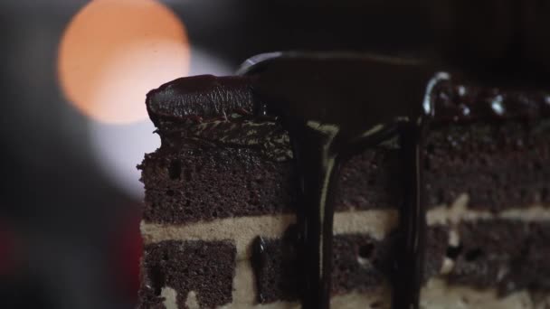 De chef-kok completeert de decoratie van het dessert en giet de gesneden taart plak met hete pure chocolade close-up — Stockvideo